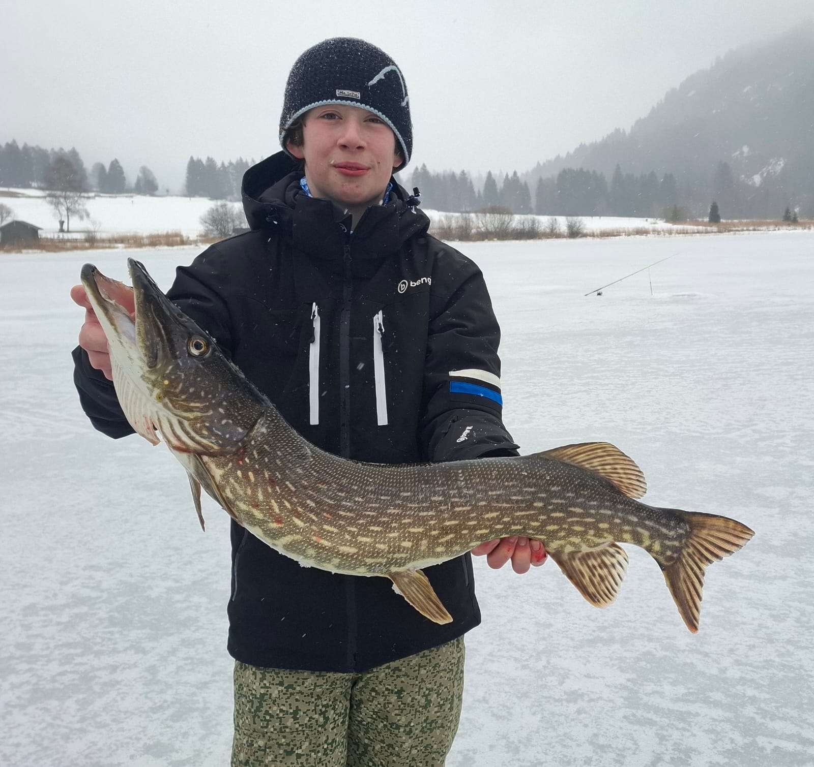 Leo Faubel hält stolz einen gefangenen Hecht beim Angeln in der Natur